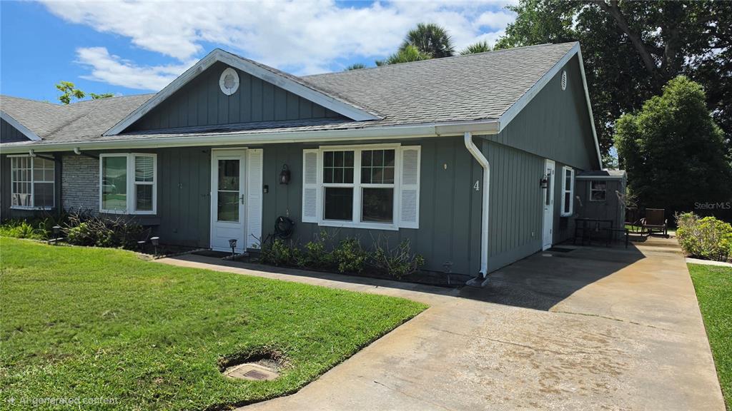 A single-story house with gray vertical siding, a shingled roof, and a concrete driveway — 4 BIRDIE DRIVE, NEW SMYRNA BEACH, FL