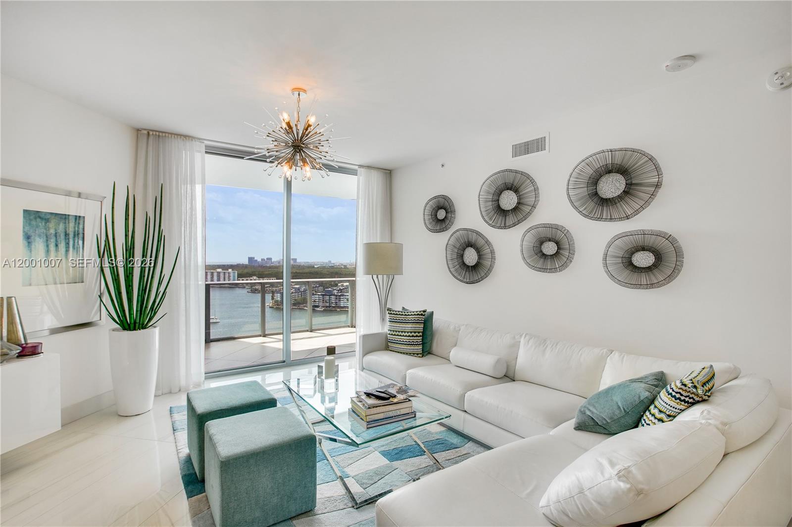 A bright living room features a white sectional sofa, glass coffee table, and balcony view — 17111 Biscayne Blvd # 2008, North Miami Beach FL 33160, NORTH MIAMI BEACH, FL