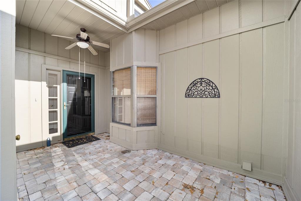 An exterior view of a multi-unit townhouse complex featuring beige garage doors and brick accents — 1906 SE CLATTERBRIDGE ROAD SE, OCALA, FL