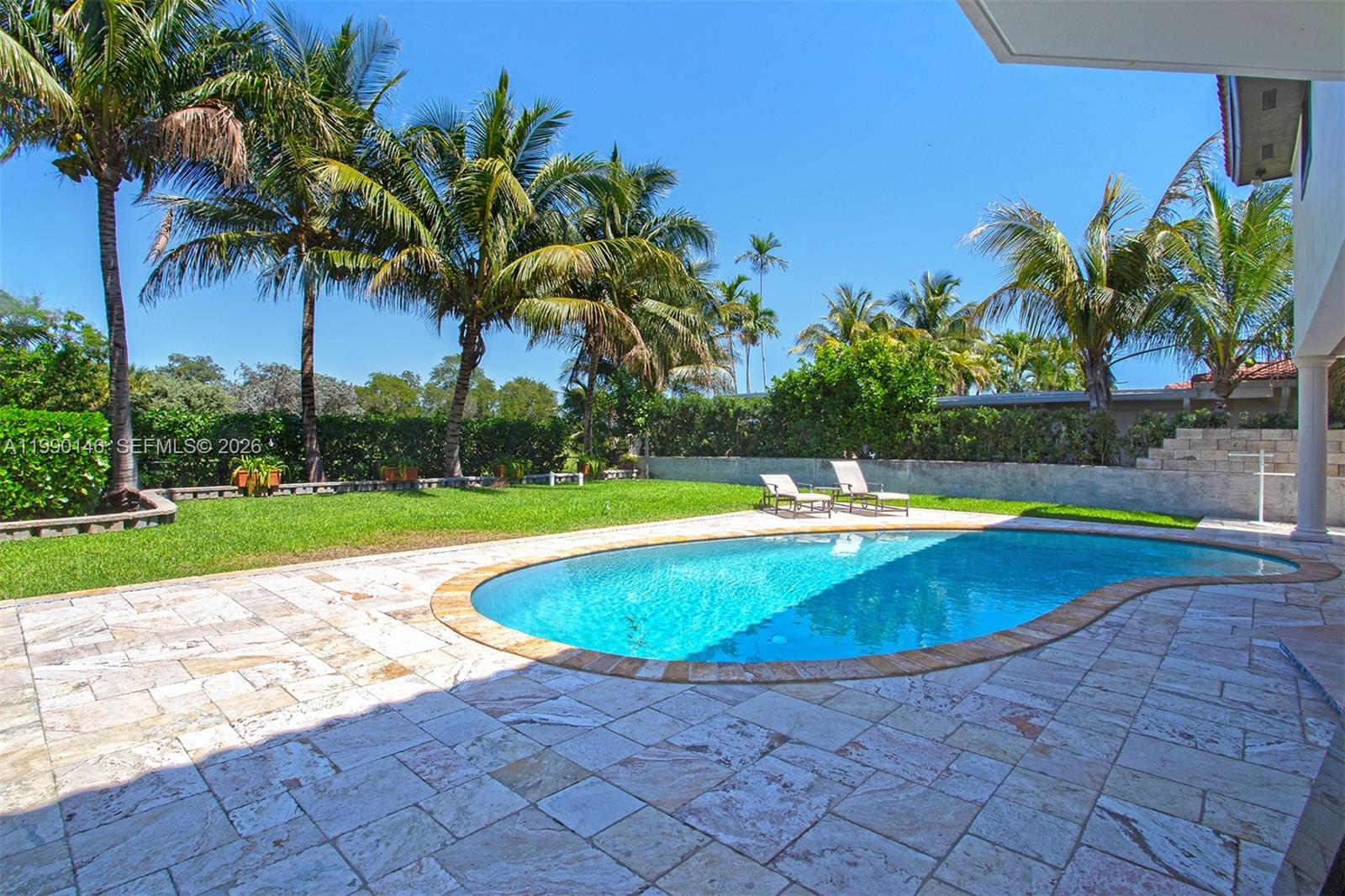 A backyard features a swimming pool, patio furniture, a dining set, and palm trees — 545 S Shore Dr, Miami Beach FL 33141, MIAMI BEACH, FL