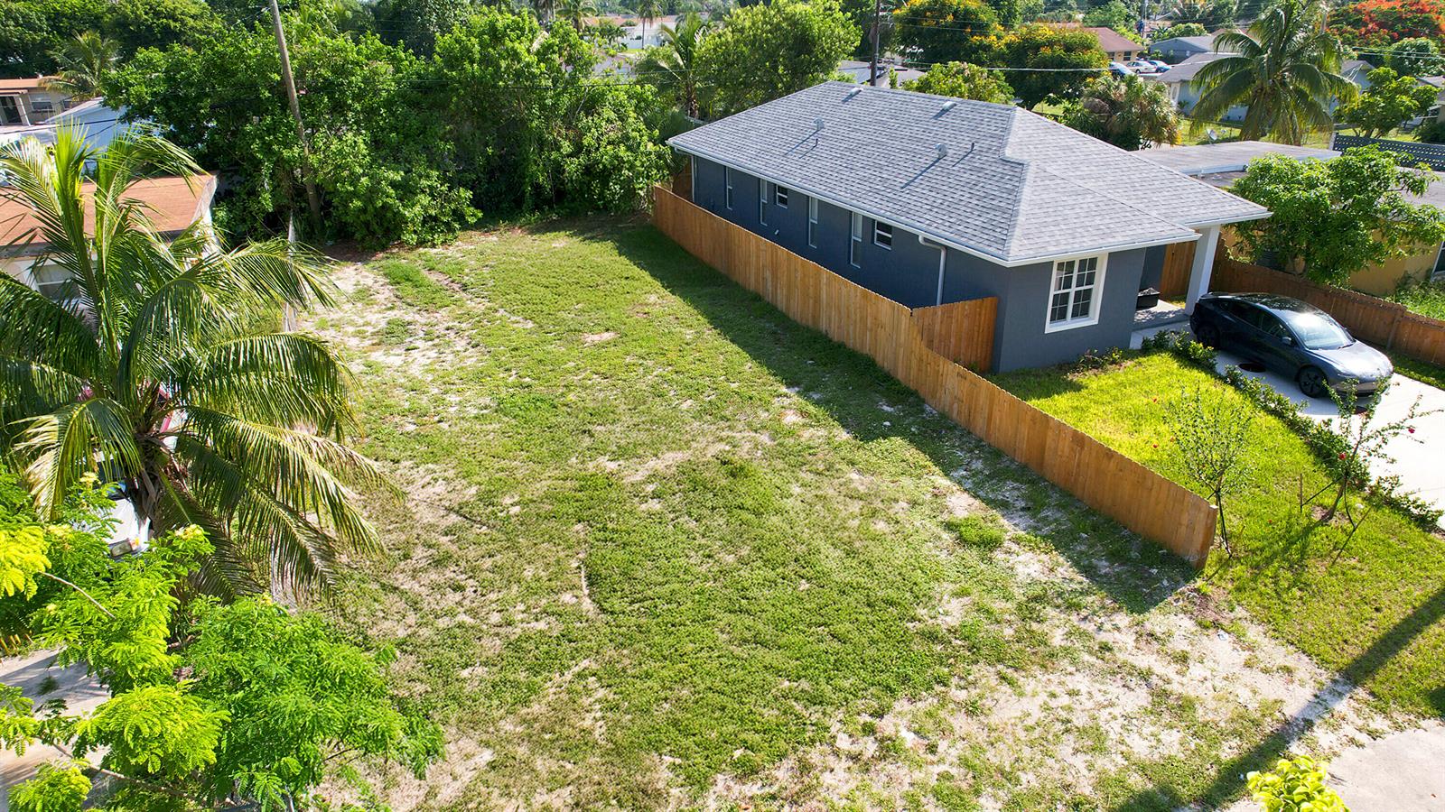 An aerial view shows a house with a gray roof next to a vacant lot — 1141 Peak Road, Lake Worth FL 33462, LAKE WORTH, FL