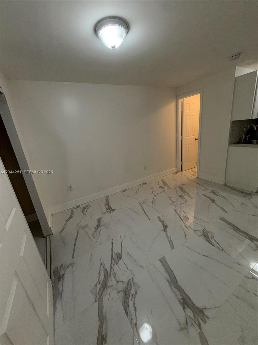 A room with white walls, a flush-mount light fixture, and white marble-patterned tile flooring — 6497 W 8th Ln # 6497, Hialeah FL 33012, HIALEAH, FL
