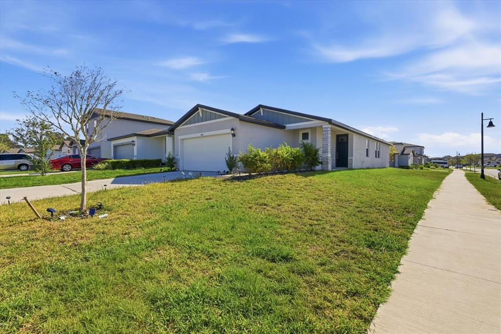 A single-story suburban house with a two-car garage and a front lawn — 2301 E NEWSOME ROAD, PLANT CITY, FL