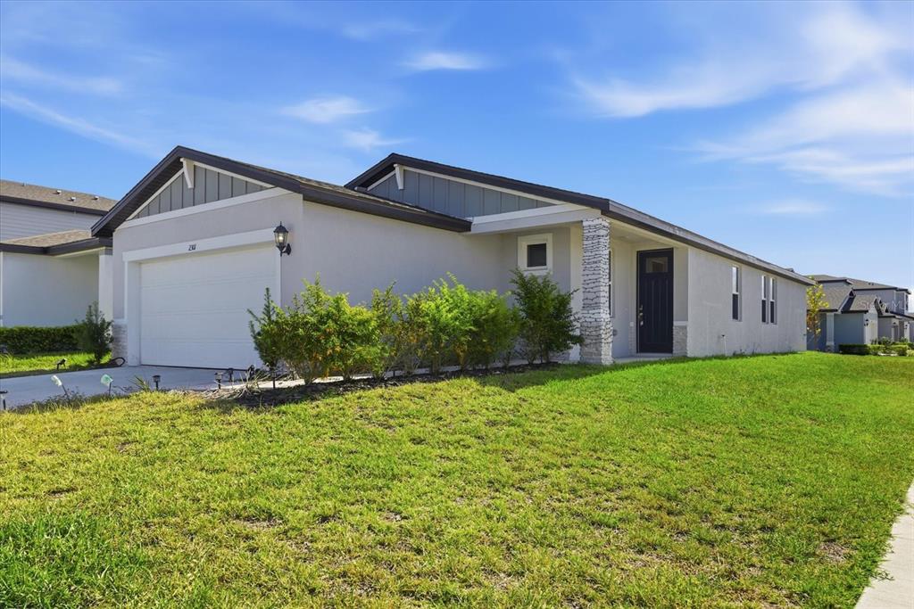 A single-story house with a white garage, dark front door, and a grassy front yard — 2301 E NEWSOME ROAD, PLANT CITY, FL