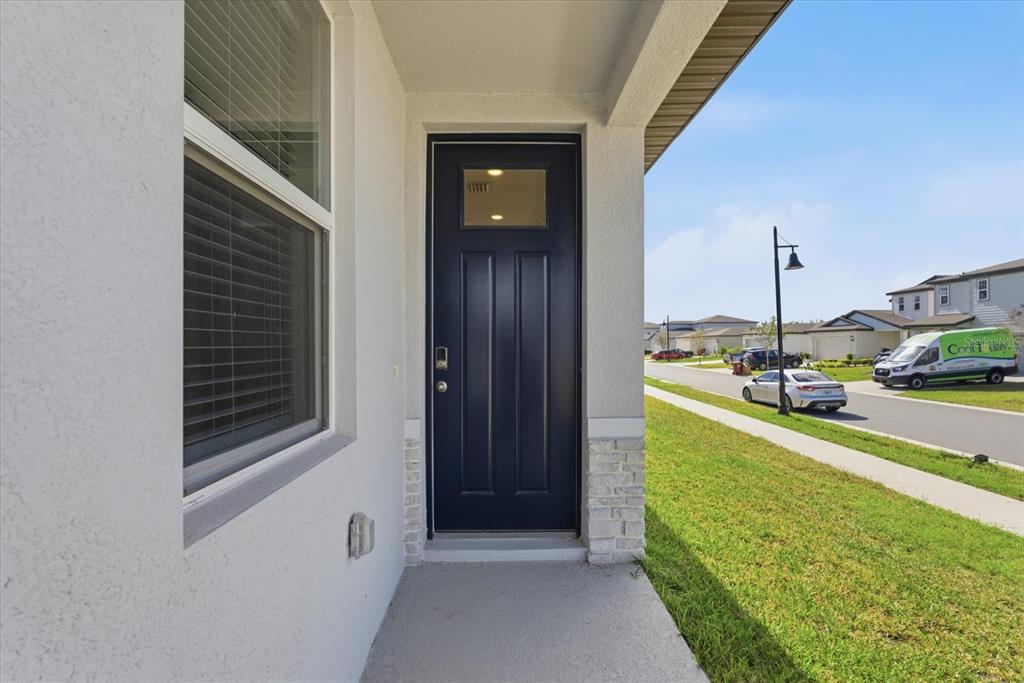 A dark blue front door with a small window sits under a covered porch — 2301 E NEWSOME ROAD, PLANT CITY, FL
