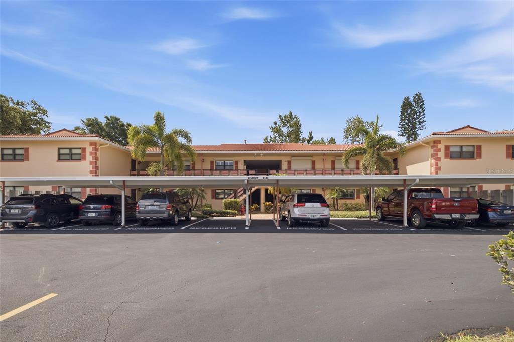 A two-story apartment building with a covered parking area in the foreground — 8140 TERRACE GARDEN DRIVE UNIT 103, ST PETERSBURG, FL