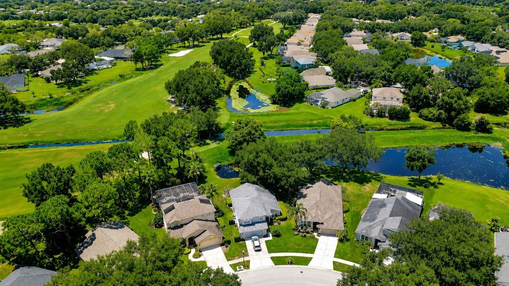 An aerial view shows several suburban houses situated along a golf course and small ponds — 5616 ROCKFIELD LOOP, VALRICO, FL