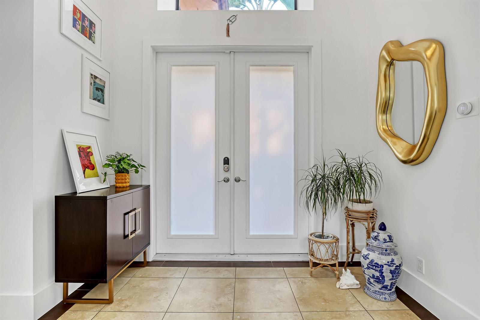 A bright entryway features a double glass door, tile flooring, a dark cabinet, and decor — 6532 Via Rosa, Boca Raton FL 33433, BOCA RATON, FL
