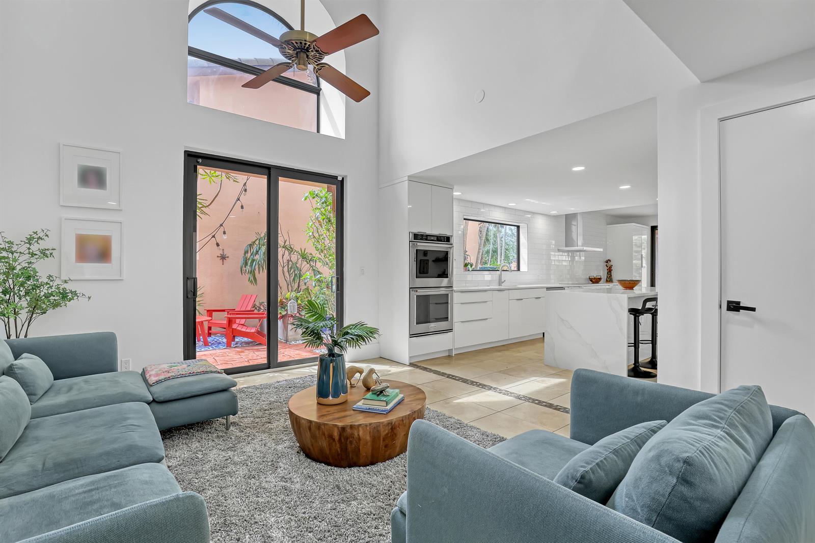 A living room with a vaulted ceiling opens to a kitchen and a patio area — 6532 Via Rosa, Boca Raton FL 33433, BOCA RATON, FL