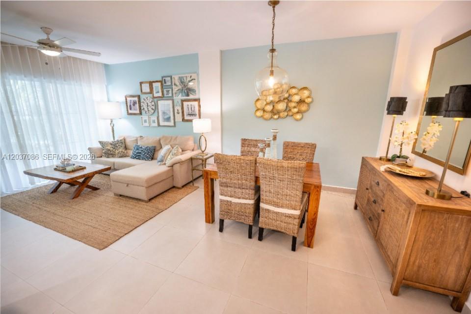 This open-concept living and dining area features light blue walls, wicker chairs, and tile flooring — 0 El hicoteco # 0, FL