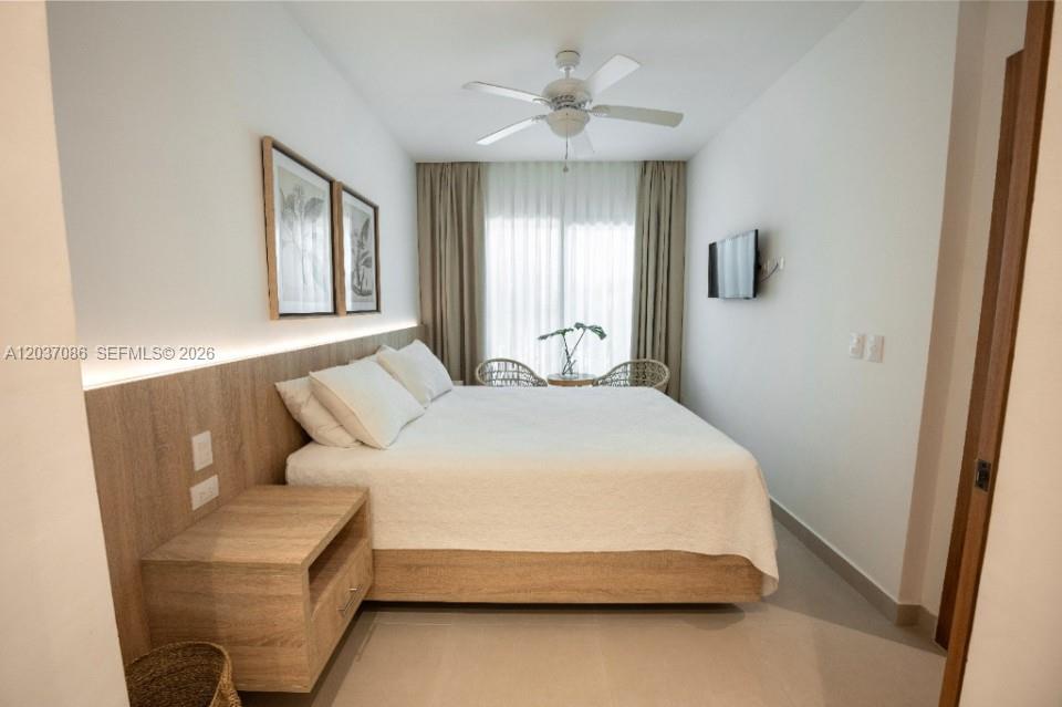 A bedroom features a bed with a wooden headboard, a nightstand, and a ceiling fan — 0 El hicoteco # 0, FL