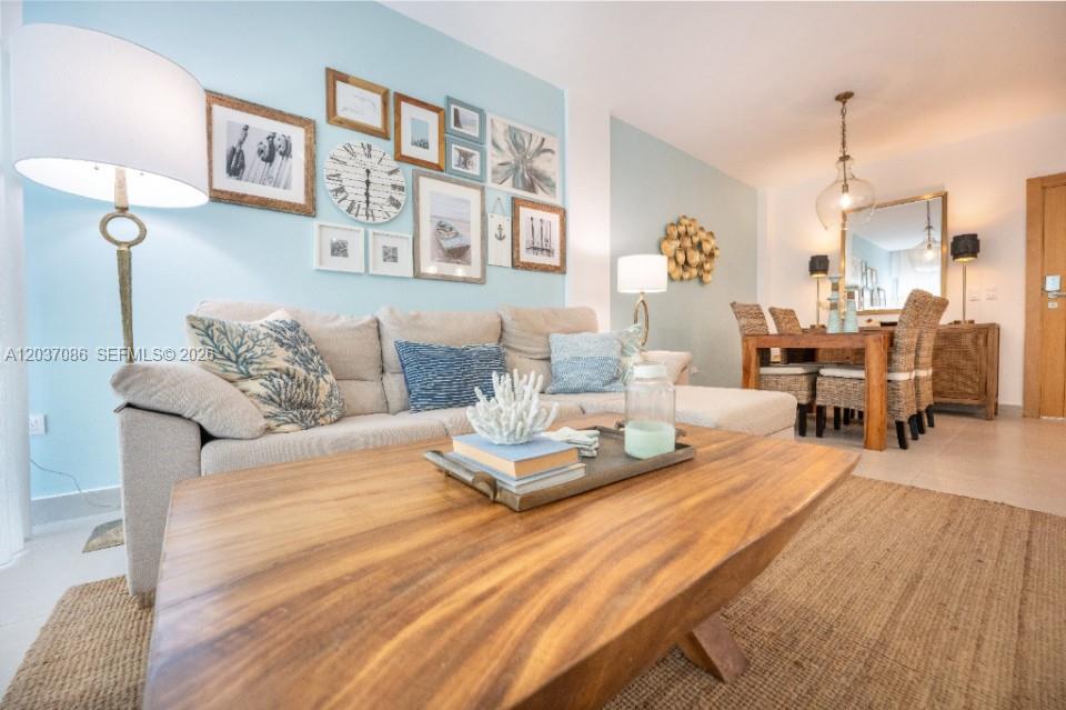 A living room features a light blue accent wall with a gallery wall and sofa — 0 El hicoteco # 0, FL