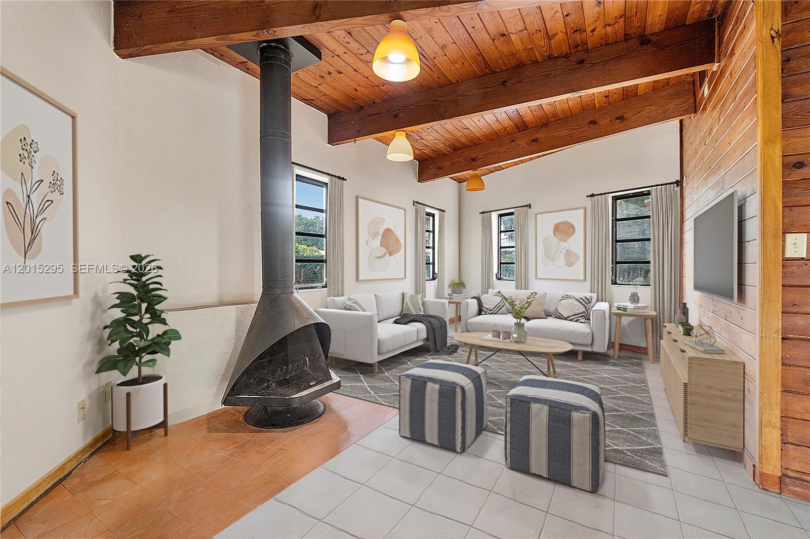 A living room features a vaulted wood-plank ceiling, exposed beams, and a freestanding metal fireplace — 4561 NW 79th Ave, Lauderhill FL 33351, LAUDERHILL, FL
