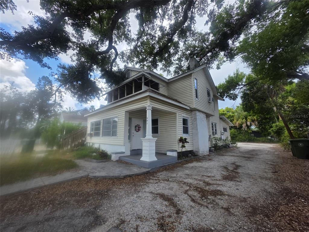 A two-story house with light-colored siding, a front porch, and large overhanging oak trees — 602 W 26TH STREET, BRADENTON, FL