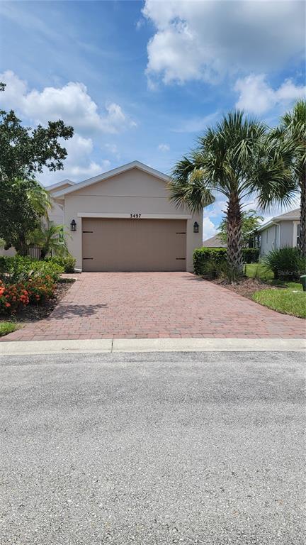A beige house with a brick paver driveway and a single-car garage — 3497 FALLBROOK DRIVE, KISSIMMEE, FL
