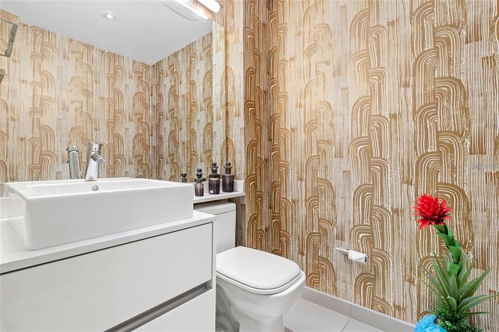 A modern bathroom features a white vessel sink, a toilet, and gold patterned wallpaper — 25 MUÑOZ RIVERA AVE UNIT 614, SAN JUAN, PR