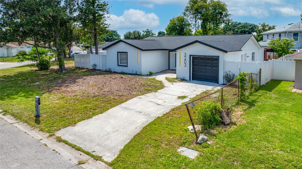 A single-story house with a white exterior, dark roof, and a concrete driveway — 3203 RIVER COVE DRIVE, TAMPA, FL