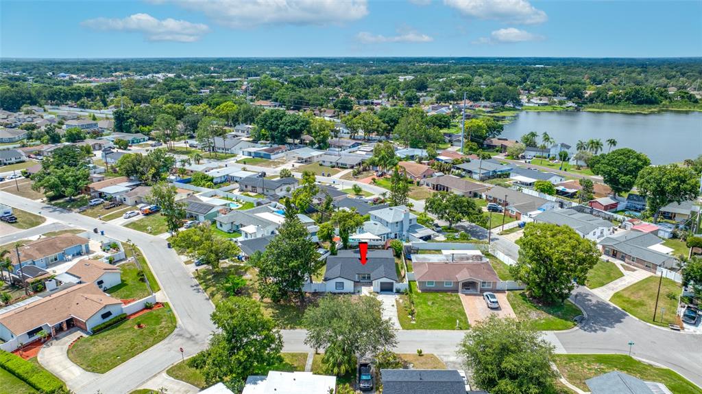 An aerial view shows a residential neighborhood with a red arrow pointing to a house — 3203 RIVER COVE DRIVE, TAMPA, FL