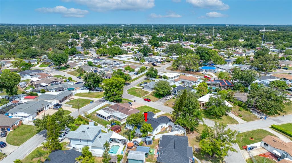 An aerial view shows a residential neighborhood with a single-story house marked by a red arrow — 3203 RIVER COVE DRIVE, TAMPA, FL