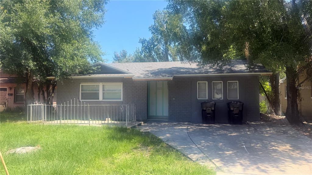 A single-story gray brick house with a front lawn, driveway, and metal porch railing — 625 19TH STREET, ORLANDO, FL