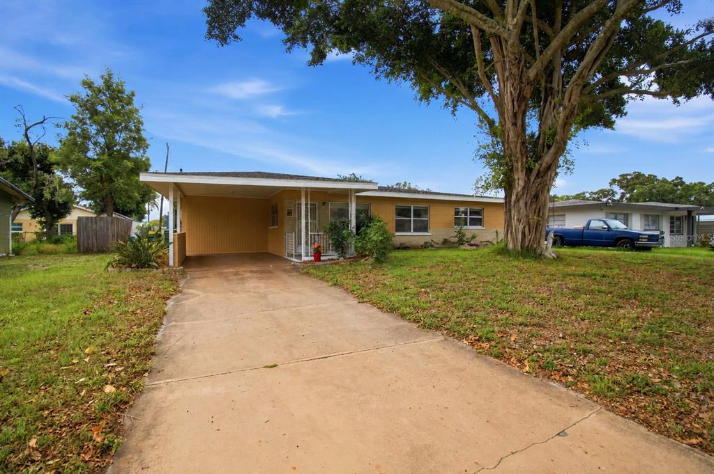 A single-story house with a carport and a large tree in the front yard — 330 CROSBY COURT, SARASOTA, FL