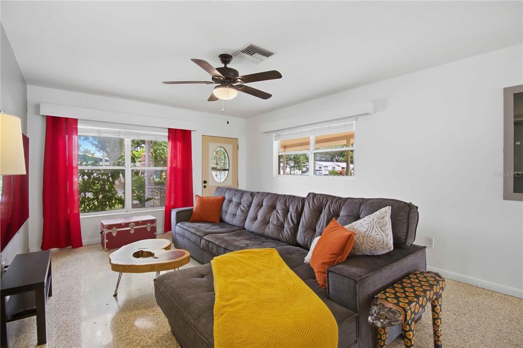 A living room features a gray sectional sofa, a live-edge coffee table, and red curtains — 330 CROSBY COURT, SARASOTA, FL