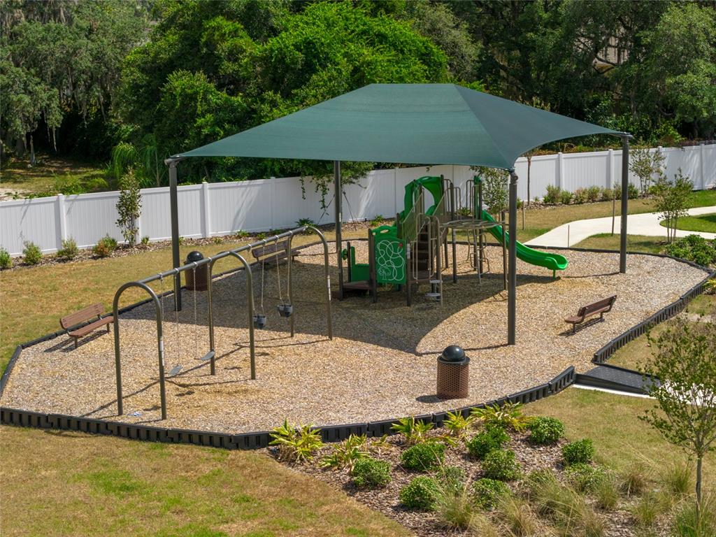 An aerial view of a playground featuring a shaded structure, swings, and a slide — 6140 SUCCESS WAY, ST CLOUD, FL