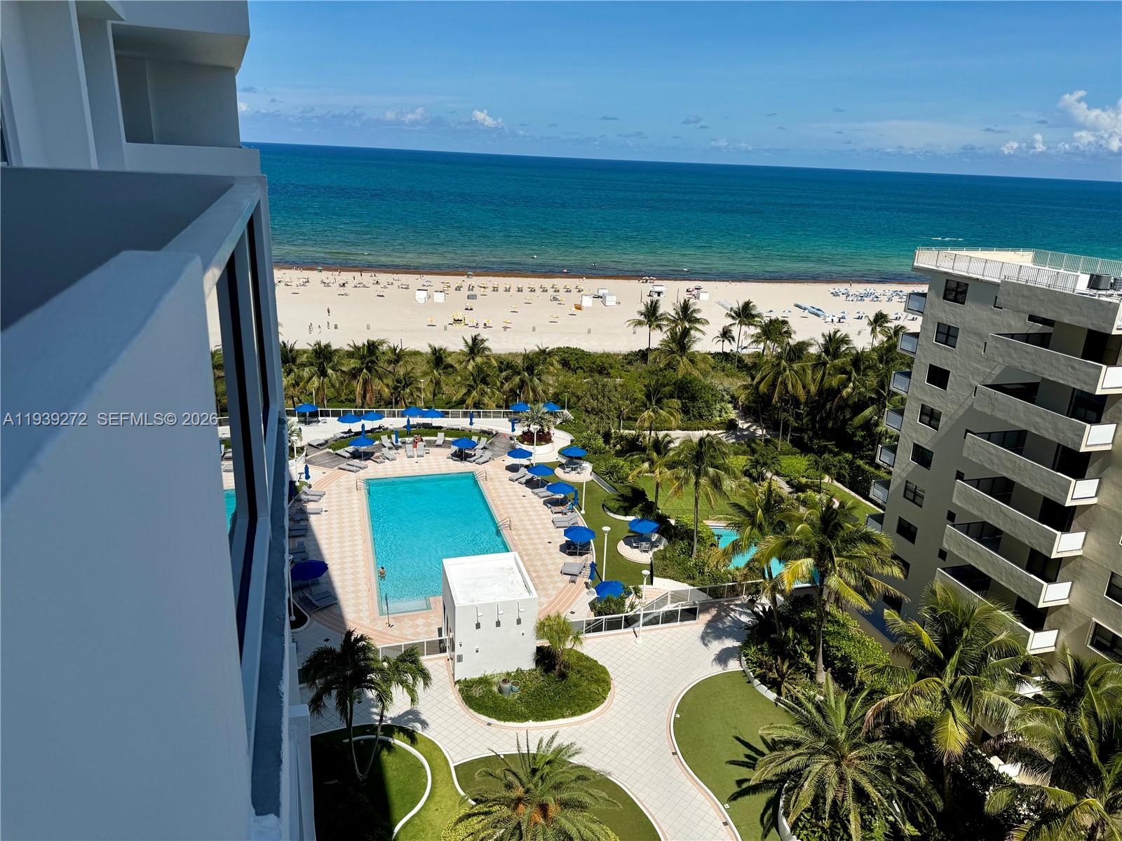 An elevated view shows a swimming pool, palm trees, and a beach along the ocean — 100 Lincoln Rd # 1230, Miami Beach FL 33139, MIAMI BEACH, FL
