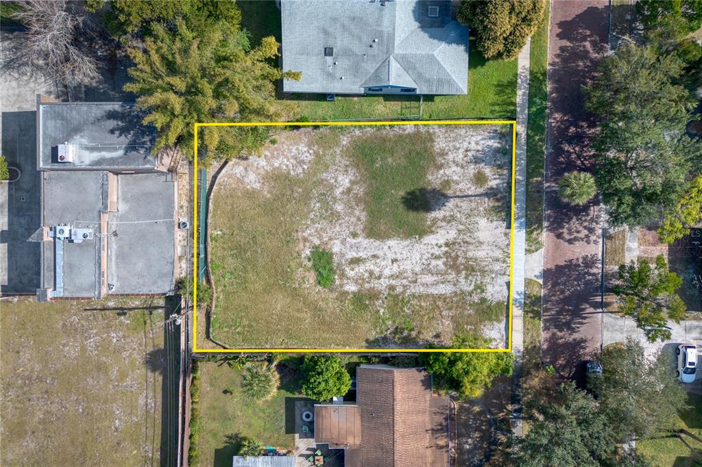 An aerial view shows a vacant, rectangular residential lot outlined in yellow — 307 E HARVARD STREET, ORLANDO, FL