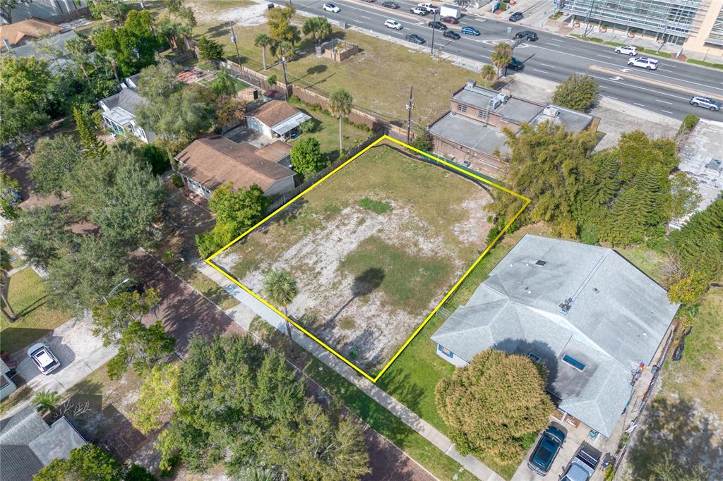 An aerial view shows a vacant, rectangular lot outlined in yellow between two residential properties — 307 E HARVARD STREET, ORLANDO, FL