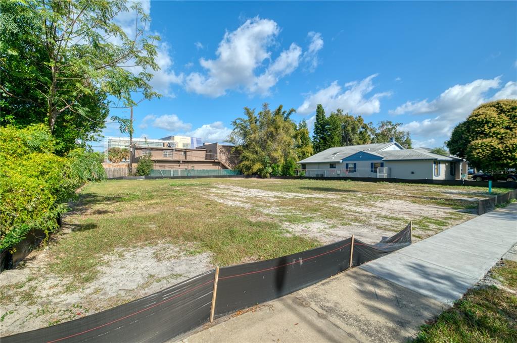 A vacant, cleared residential lot is bordered by a sidewalk, black silt fencing, and trees — 307 E HARVARD STREET, ORLANDO, FL