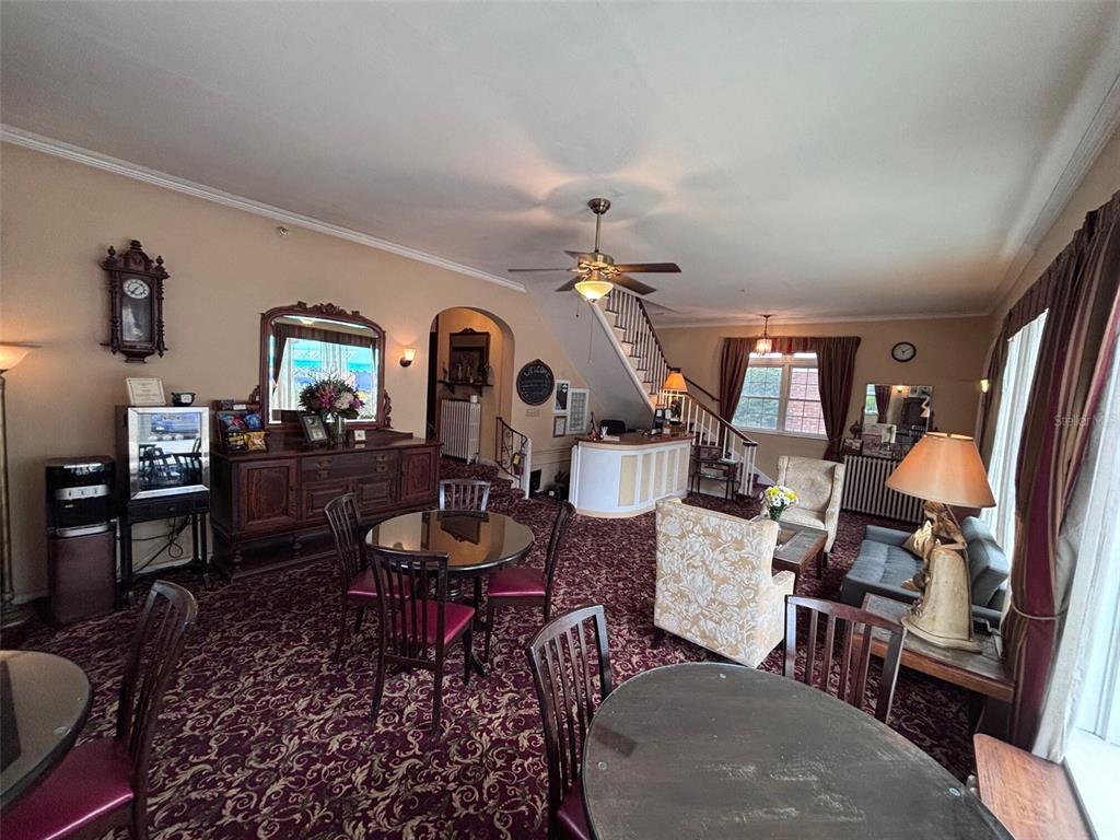 A lobby area features patterned carpeting, a wooden sideboard, a staircase, and several seating arrangements — 342 3RD AVENUE N, ST PETERSBURG, FL