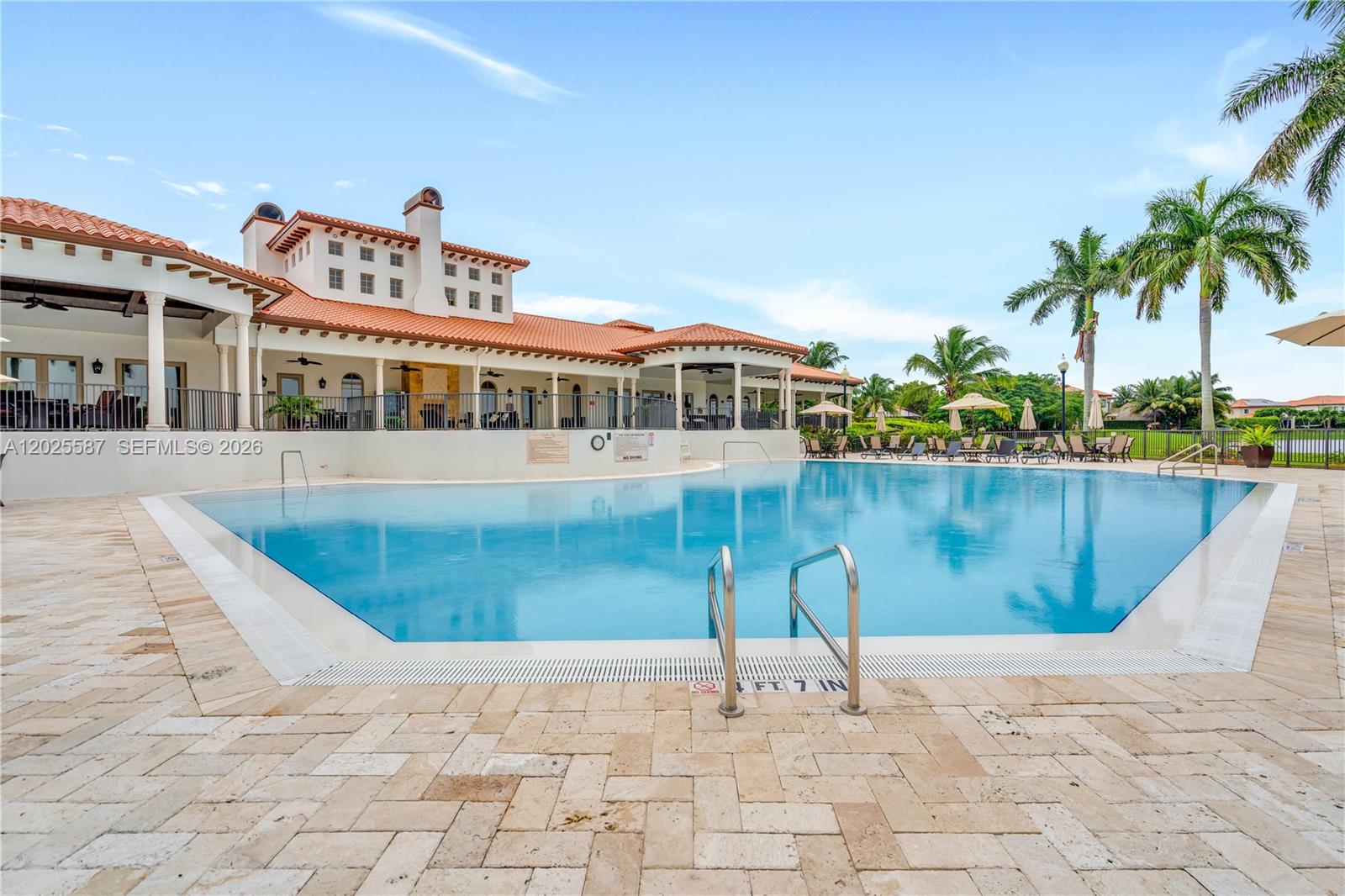 A swimming pool sits in front of a large building with a terracotta tile roof — 19508 SW 79th Ct, Cutler Bay FL 33157, CUTLER BAY, FL