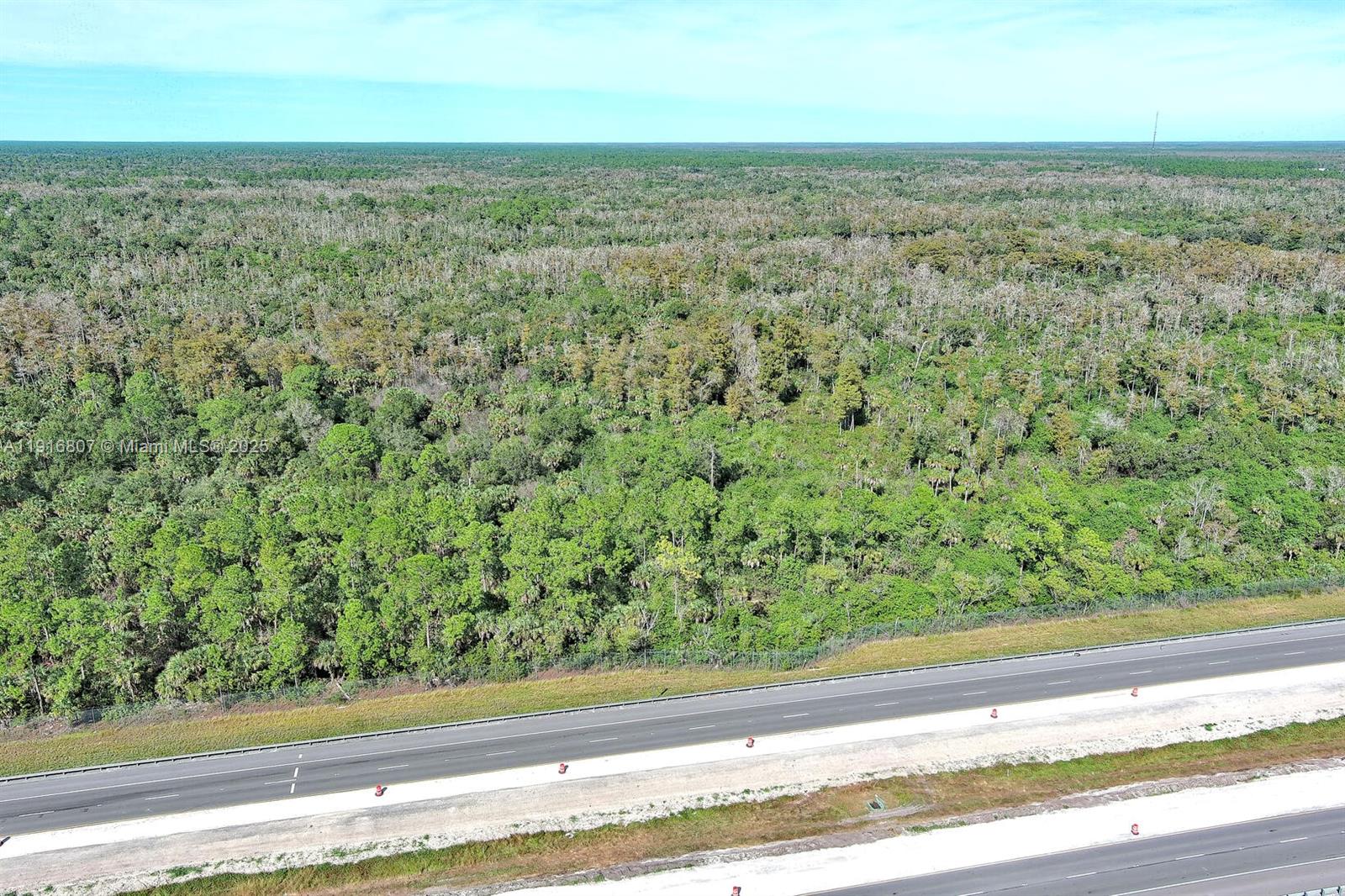 An aerial view shows a dense forest bordering a multi-lane highway — 0 Alligator Alley, Naples FL 34117, NAPLES, FL