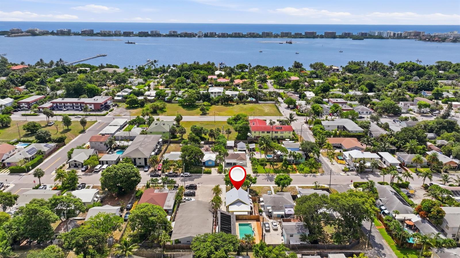 An aerial view shows a residential neighborhood with a house featuring a swimming pool — 1021 S N Street, FL 33460, FL