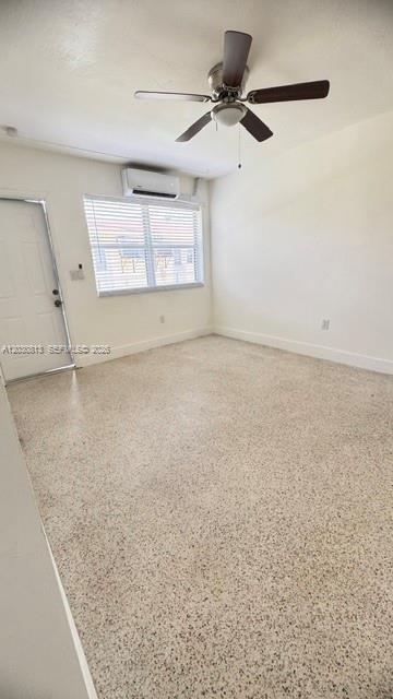An empty room features a ceiling fan, a wall-mounted air conditioner, and speckled flooring — 3085 W Flagler St # 3, Miami FL 33135, MIAMI, FL
