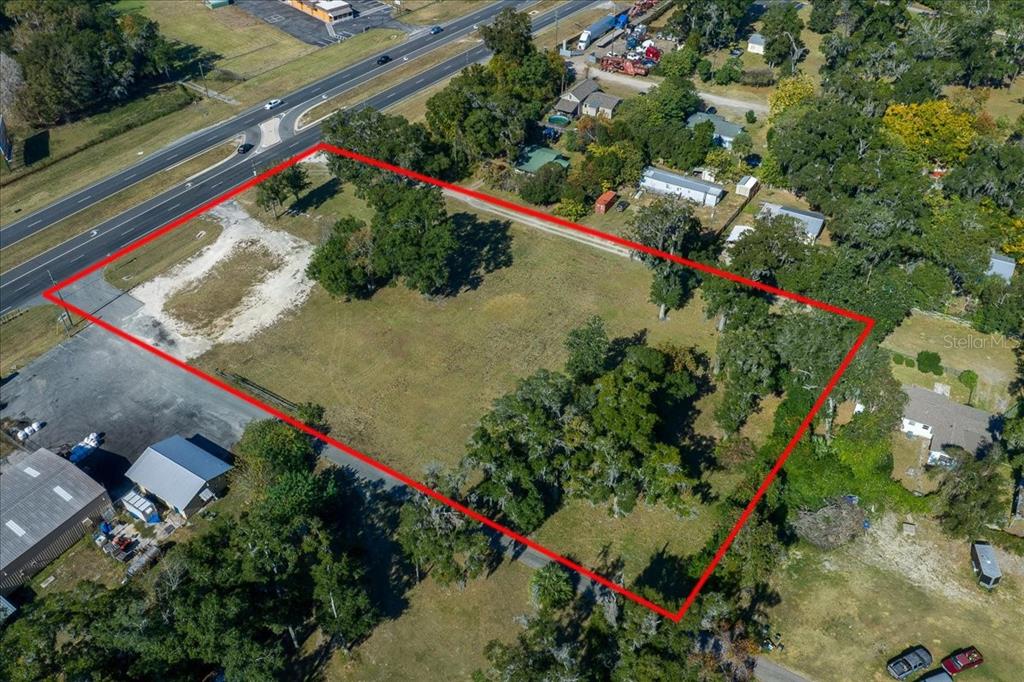 An aerial view shows a rectangular plot of land outlined in red near a highway — 1350 NW 47TH STREET, OCALA, FL