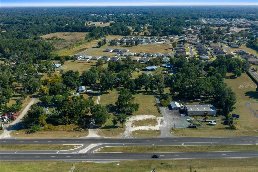 An aerial view shows a large plot of land with buildings near a multi-lane highway — 1350 NW 47TH STREET, OCALA, FL
