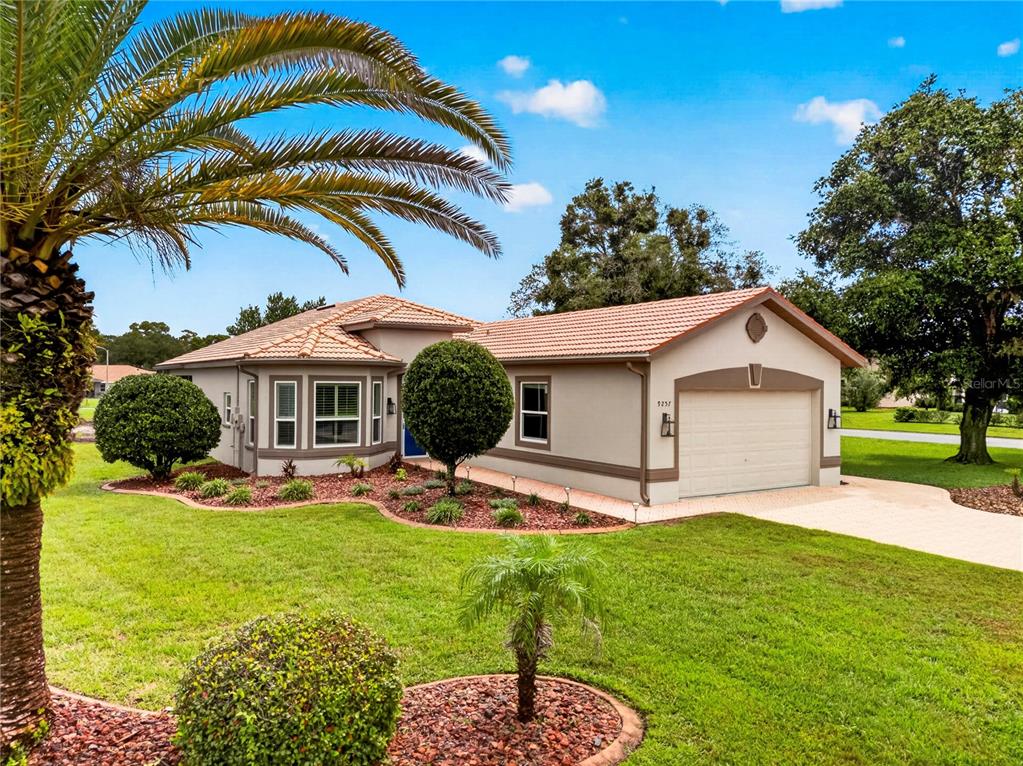 A single-story house with a tile roof, a two-car garage, and a landscaped front yard — 9257 BONNIE COVE DRIVE, WEEKI WACHEE, FL