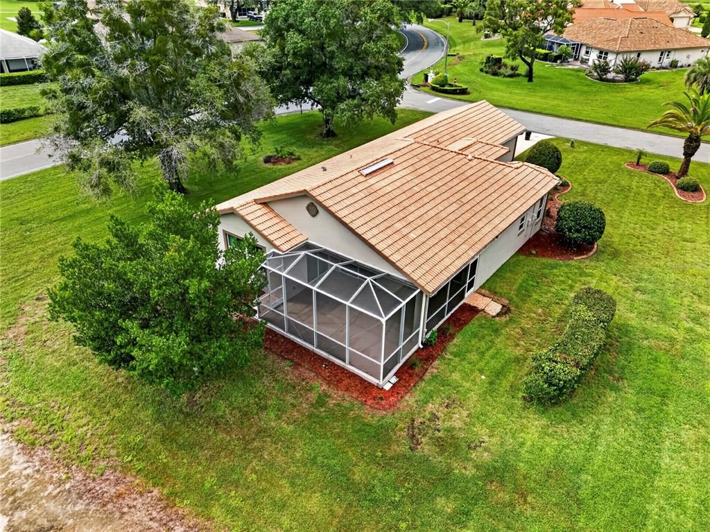 An aerial view shows a house with a tiled roof and a screened-in back porch — 9257 BONNIE COVE DRIVE, WEEKI WACHEE, FL