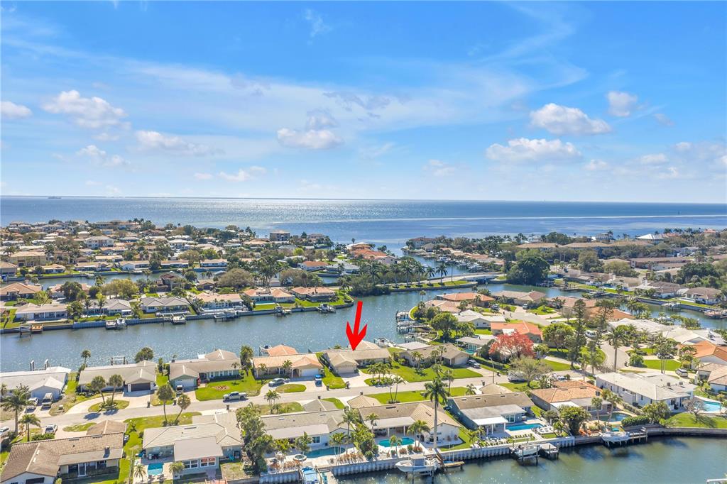 An aerial view shows a residential neighborhood with waterfront homes along a canal — 1964 MASSACHUSETTS AVENUE NE, ST PETERSBURG, FL