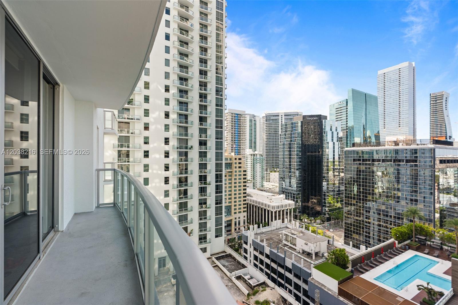 A high-rise balcony overlooks a dense city skyline with a swimming pool below — 1050 Brickell Ave # 2112, Miami FL 33131, MIAMI, FL