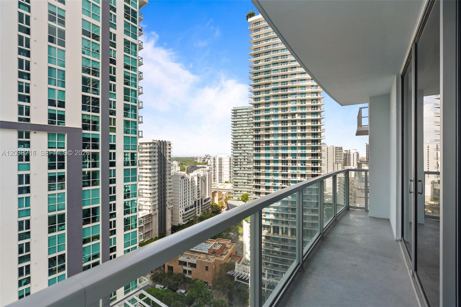 A high-rise balcony with a glass railing overlooks a dense urban cityscape — 1050 Brickell Ave # 2112, Miami FL 33131, MIAMI, FL
