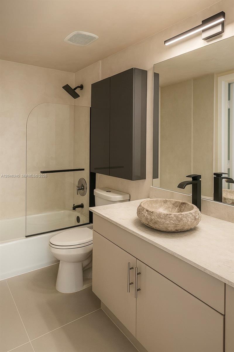 A modern bathroom features a stone vessel sink, a floating vanity, and a glass-enclosed tub — 1861 NW S River Dr # 1505, Miami FL 33125, MIAMI, FL