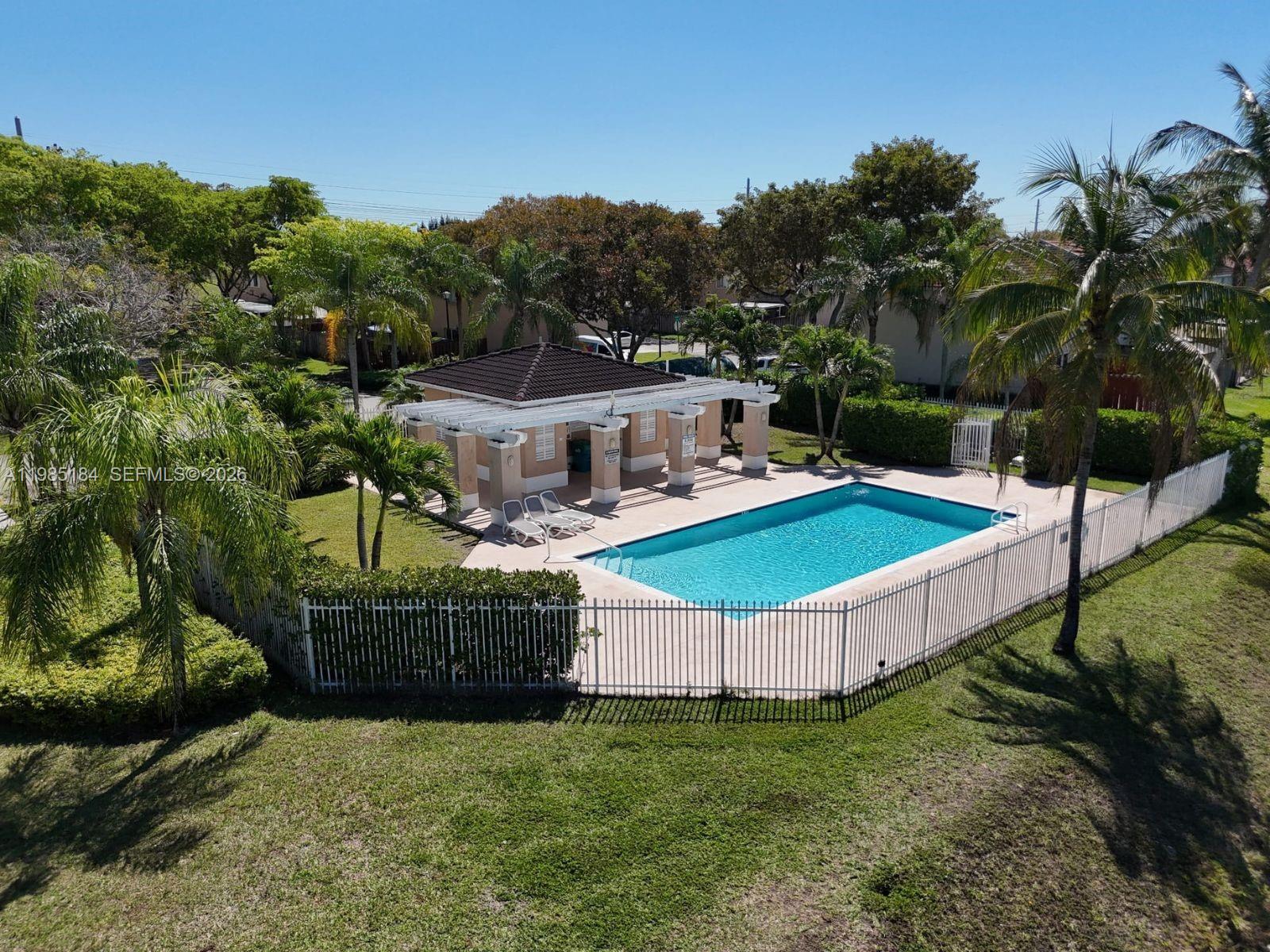 An aerial view shows a rectangular swimming pool with a covered patio area and landscaping — 13926 SW 175th Ter, Miami FL 33177, MIAMI, FL