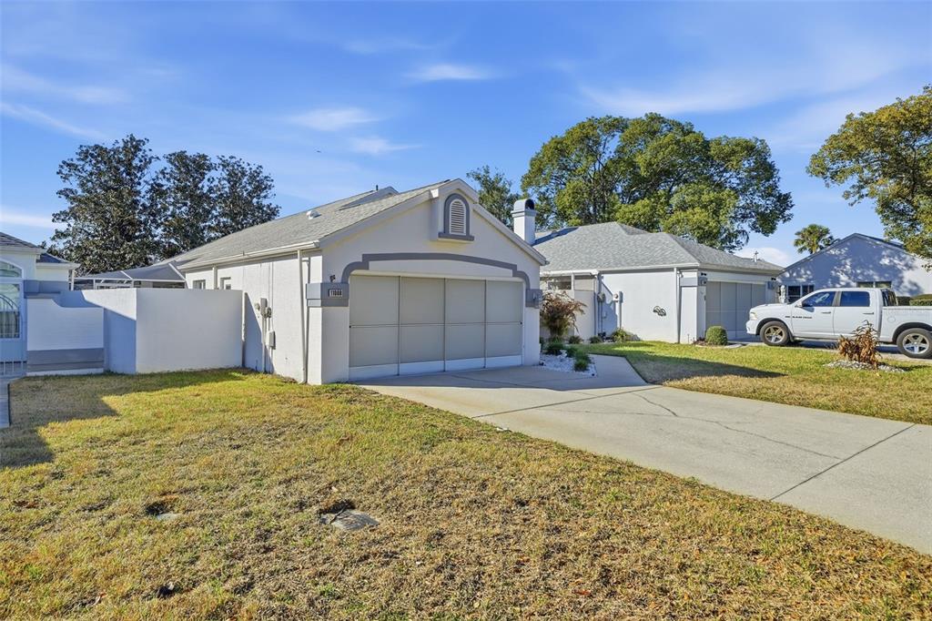 A single-story house with a white stucco exterior, a two-car garage, and a concrete driveway — 11008 CASA GRANDE, SPRING HILL, FL