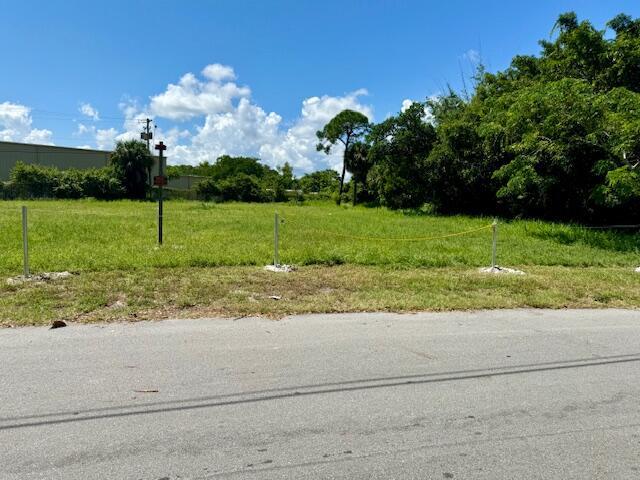 A grassy vacant lot is bordered by a chain-link fence and dense trees — 2350 Shenandoah Road NE, Palm Bay FL 32905, PALM BAY, FL
