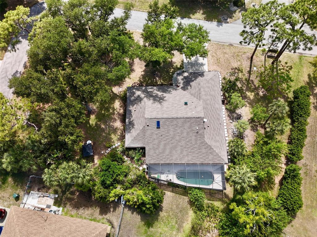 An aerial view shows a house with a screened pool and surrounding trees — 98 HOURGLASS DRIVE, VENICE, FL