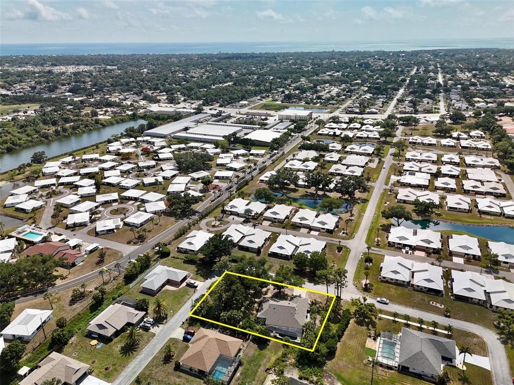 An aerial view shows a residential neighborhood with a highlighted house and surrounding properties — 98 HOURGLASS DRIVE, VENICE, FL