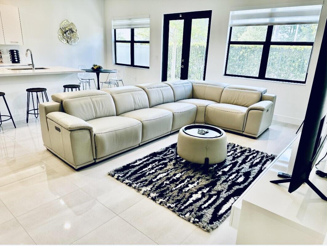 A modern living room features a large beige sectional sofa, a patterned rug, and tile flooring — 17451 SW 41st Street, Miramar FL 33029, MIRAMAR, FL